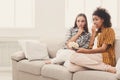 Frightened young women watching TV at home Royalty Free Stock Photo