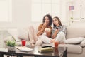 Frightened young women watching TV at home Royalty Free Stock Photo