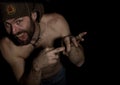 Frightening bearded man showing middle finger. strange Russian man with a naked torso and a woolen hat. free space for