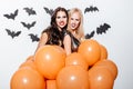 Frightening women with halloween makeup holding balloons and showing teeth