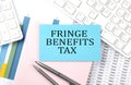 FRINGE BENEFITS TAX text on blue sticker on chart with calculator and keyboard,Business concept Royalty Free Stock Photo