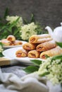 Fripons, French pastries. Apricot jam puff pastry rolls for summer tea and white flowers Royalty Free Stock Photo