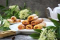 Fripons, French pastries. Apricot jam puff pastry rolls for summer tea and white flowers Royalty Free Stock Photo