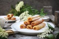 Fripons, French pastries. Apricot jam sweet puff pastry rolls and spring elderberry flowers Royalty Free Stock Photo