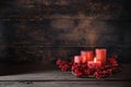 Frist Advent with red berry decoration and candles in a wreath, one is lighted, holiday home decor against a dark rustic wooden