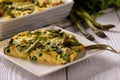 Fritata with asparagus on wooden background. Royalty Free Stock Photo