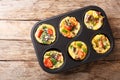 Frittata in the form of egg muffins with vegetables, cheese, bacon and mushrooms close-up in a baking dish. Horizontal top view Royalty Free Stock Photo