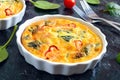 Frittata with fresh vegetables and spinach. Italian omelet in ceramic forms Royalty Free Stock Photo