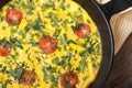 Frittata with green onions, tomatoes in a pan top view Royalty Free Stock Photo