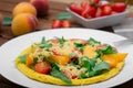 Frittata with peach, vegetables and cheese in a white plate on the rustic wooden background. Top view Royalty Free Stock Photo