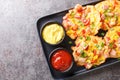 Fritters with corn, ham pepper and onion served with sauces close-up on a plate. horizontal top view Royalty Free Stock Photo
