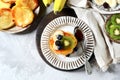 Fritters with honey, banana, blueberries and kiwi on a gray background