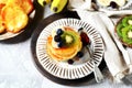 Fritters with honey, banana, blueberries and kiwi on a gray background