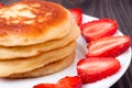 Fritters on a plate with strawberries wooden background