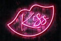 Kiss neon sign with neon lips on a dark wooden wall, 3D illustration with red heart background Royalty Free Stock Photo