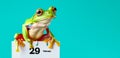 Frog sitting atop a calendar marked with February 29. Leap Day Calendar Date