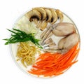frog soup, carrots, noodles, onions, mushrooms with seafood, calamari, shrimps in a plate on white background top view