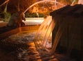 Frogs statue fountain spraying water at night in yellow warm lights in Holon Herzel park