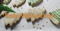 Frohe weihnachten text in orange over decorated christmas cookies on white background