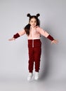 Frolic brunette kid girl in modern fashion pink brown sportwear is jumping having fun