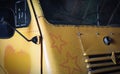 The front of an abandoned old yellow truck