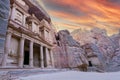 Front of Al-Khazneh in Lost city of Petra, orange sunset sky above