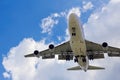 Front bottom image large commercial passenger aircraft or cargo transportation airplane flying on blue sky with cloud and spread Royalty Free Stock Photo