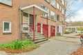 the front of a brick apartment building with red doors