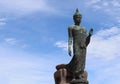 Front of Buddha statue is standing isolated on blue sky and white cloud background closeup at Phutthamonthon park, Thailand.