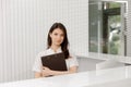 In front of the camera beautiful medical assistant posing to the camera at reception desk she smiling cute holding a map Royalty Free Stock Photo