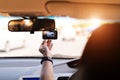 Front camera car recorder, woman set video recorder next to a rear view mirror