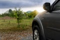 Beside of front car with drop on water on the car. Car gray color. Front side with nautre of graden green grass and trees after ra Royalty Free Stock Photo