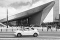 In front of Central Station Rotterdam with a passing white car. Royalty Free Stock Photo