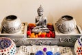 Front close up of shot of a Buddha statue with colored stones and beautiful spherical cups in Interior decoration concept