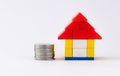 Front close up shot of a lego home with piled coins and copy space Royalty Free Stock Photo