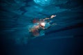 Front crawl. Speed. Young woman, professional swimmer in goggles and cap training, swimming in pool indoors. Underwater Royalty Free Stock Photo