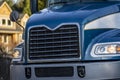 Front of dark blue big rig semi truck with chrome grille and headlight