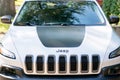 Front detail hood grill of a white Jeep Cherokee Trailhawk SUV