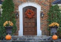 Front door of brick house with fall decorative wreath and pumpkins