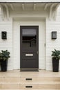 Front door, brown door, white exterior Royalty Free Stock Photo