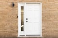 A white front door detail with a brick exterior. Royalty Free Stock Photo