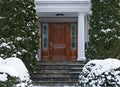 front door of house with snow covered shrubbery