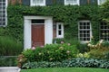 Front door of house surrounded by green vines