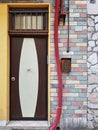 Front door next to a colorful brick wall