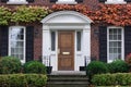 Front door of old brick house surrounded by ivy in autumn Royalty Free Stock Photo