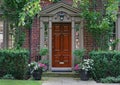 Front door of older brick house with shady garden Royalty Free Stock Photo