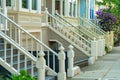 Front door railing banisters with modern victorian design in shade in the front yard of homes with foliage and houses in Royalty Free Stock Photo