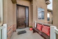 Front door with sidelight of house with bench and potted flowers at the portico Royalty Free Stock Photo