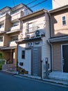 The front elevation of a very narrow, small, terraced house in a suburb of Kyoto, Japan