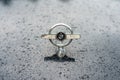 The front emblem of full-size car Mercury Turnpike Cruiser in rain of drops, close-up.